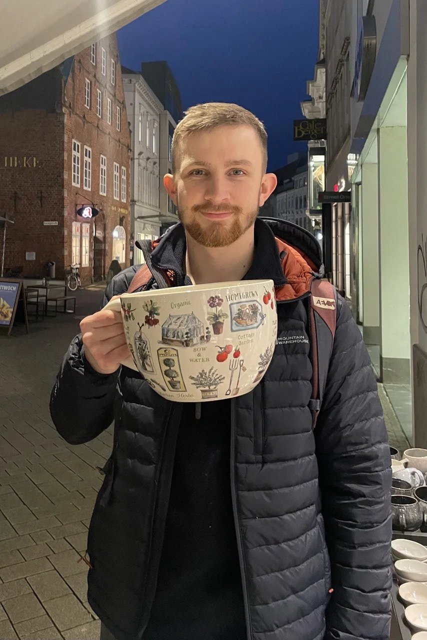 Linus Hestermeyer mit einer Kaffeetasse in der Stadt